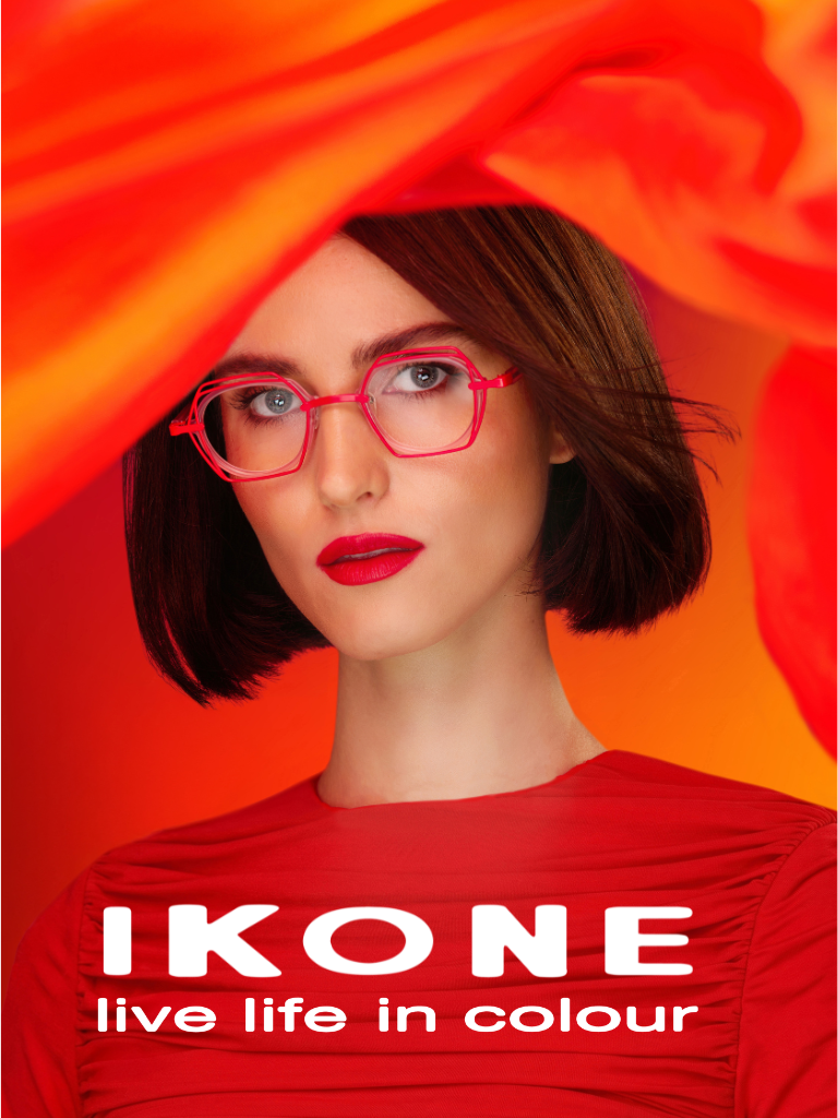 Woman with bob haircut and red glasses poses against a vibrant orange-red background. Text reads: "IKONE live life in colour.